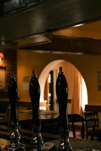 three black vases sitting on top of a table at Oliver Twist Country Inn in Wisbech