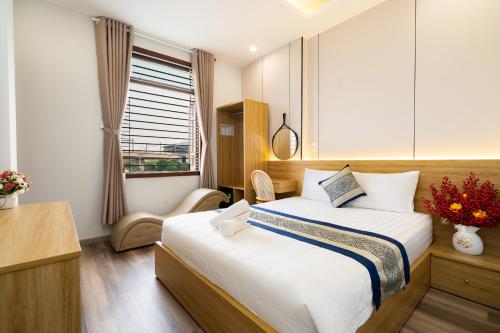 a bedroom with a bed and a desk and a window at Phuong Nam Hotel in Ho Chi Minh City