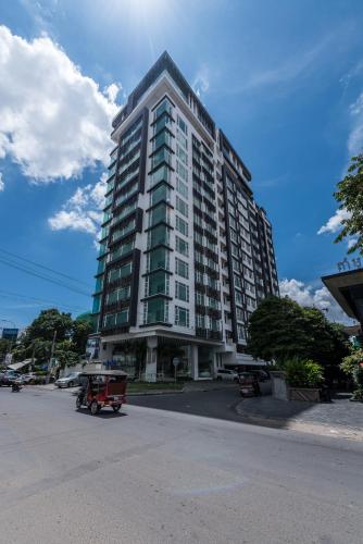 a large tall building with a red wagon in front of it at Naki Suites @ Silvertown in Phnom Penh