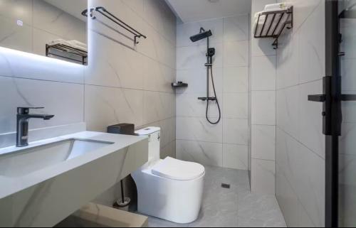 a bathroom with a toilet and a sink and a shower at 样样好民宿 in Jinghong