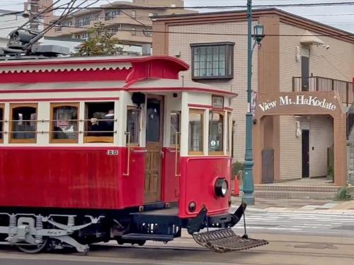 a red trolley car on a city street at Condominium View Mt Hakodate in Hakodate