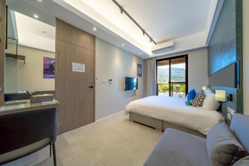 a bedroom with a bed and a sink and a television at Sunlight Heyun B&B in Yuanshan