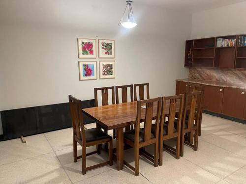 a dining room with a wooden table and chairs at New Apartment in Islamabad