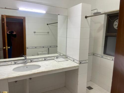 a bathroom with a sink and a person taking a picture at New Apartment in Islamabad