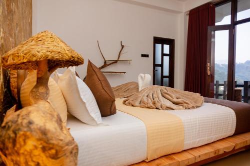 a bedroom with a large bed with pillows at Velora Inn in Ella