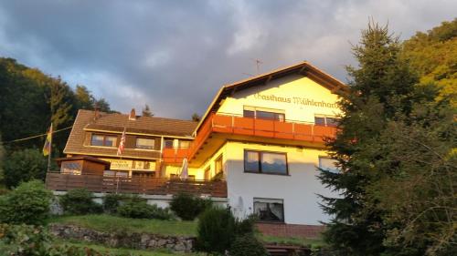 ein Haus mit Orange und Weiß in der Unterkunft Pension Mühlenhardt in Herschbroich