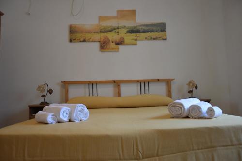 Una cama con tres toallas enrolladas encima. en Azienda Agrituristica Caridà, en Zaccanopoli