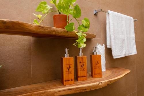 a wooden shelf with four candles in a bathroom at Velora Inn in Ella