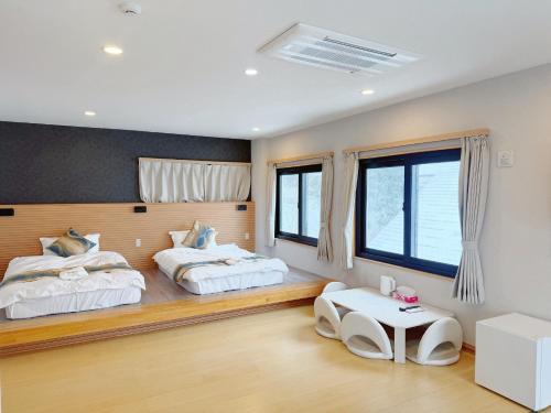 a bedroom with two beds and a table at 苗場サンバレーホテル in Minami Uonuma