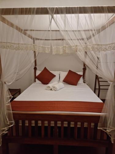 a bedroom with a bed with a canopy at Mahaweli Shades in Kandy