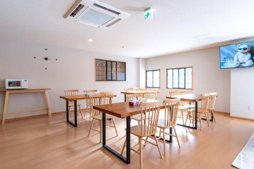 a room with tables and chairs and a tv at 苗場サンバレーホテル in Minami Uonuma