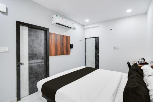 a bedroom with a bed with a black and white comforter at Super Collection O Kachiguda Bus Terminal Hyderabad in Vidya Nagar