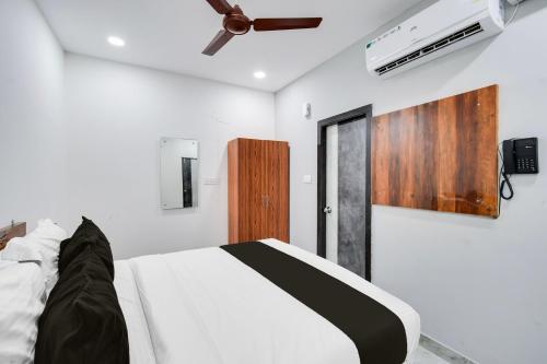 a bedroom with a bed and a ceiling fan at Super Collection O Kachiguda Bus Terminal Hyderabad in Vidya Nagar
