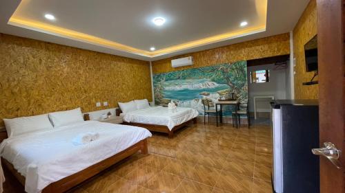 a bedroom with two beds and a painting on the wall at Baan Gamnan Resort Krabi in Ban Khao Ngam