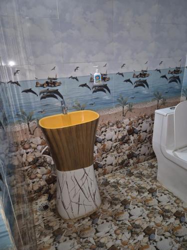 a bathroom with a toilet and a flock of birds at Om Hotel & Lodge in Baharāgora