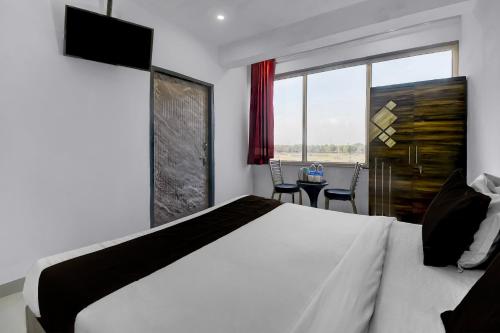 a bedroom with a large white bed and a window at Collection O Saral Bihari Temple Formerly Black Panther in Sheodāspura