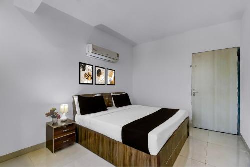 a bedroom with a large bed and a closet at Collection O Saral Bihari Temple Formerly Black Panther in Sheodāspura