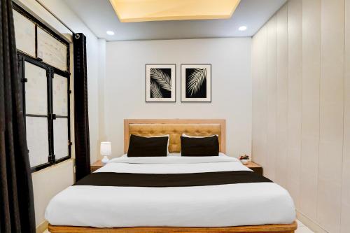 a bedroom with a large white bed with black pillows at OYO Hotel O Subedarganj Railway Junction Formerly Krishna Inn in Prayagraj