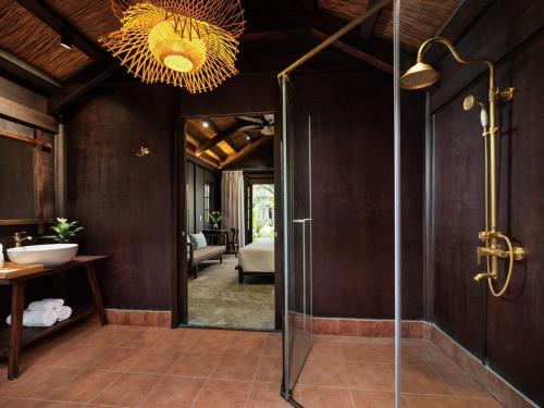 a bathroom with a shower with a glass door at La Lua Resort Ninh Binh in Ninh Binh