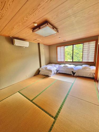a room with three beds in a room with windows at 神庭-kaniwa- in Chichibu