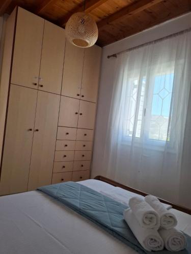a bedroom with a bed with towels and a window at Divine Island Escape in Kini