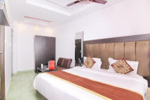 a bedroom with a large white bed with a brown headboard at Srt rajput hotel Subhash Marg Charbhag Lucknow in Lucknow