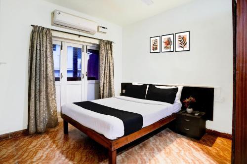 a bedroom with a bed and a window at Super Collection O Holiday Street Calangute Formerly Shruti Resort in Goa
