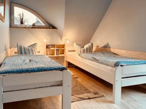 two twin beds in a room with a window at Ferienhaus Inselliebe in Vieregge