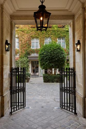 an entrance to a building with a wrought iron gate at Le Pavillon de la Reine & Spa, Place des Vosges in Paris
