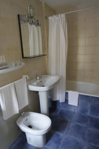 a bathroom with a toilet and a sink and a tub at La Casona de Mestas in Ponga
