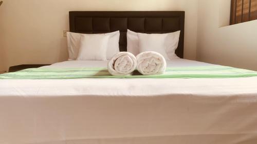 two towels are sitting on a bed at Elysian Home Villa in Madiwala