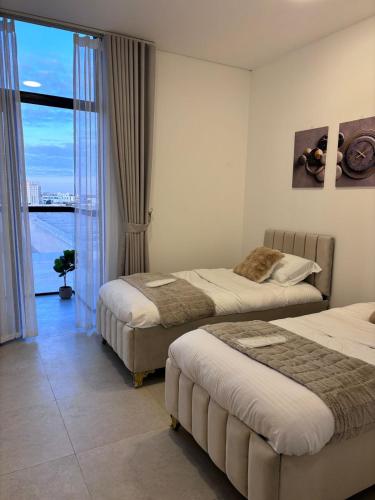 a hotel room with two beds and a window at Alaziba view in ‘Udhaybah
