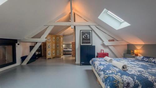 a attic bedroom with a bed and a skylight at Charmante maison de ville avec vue sur le donjon avec wifi et jardin in Gouffern en Auge
