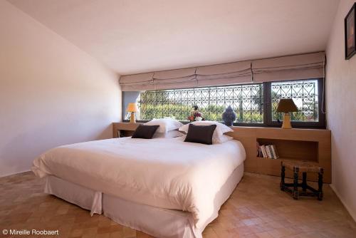 una camera da letto con un grande letto bianco e una finestra di Dar Maktoub ad Agadir