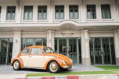 an orange and white car parked in front of a building at TUAN Hotel Bangkok near Wat Arun in Bangkok Yai