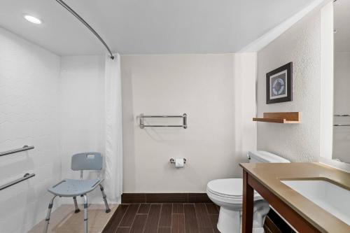 a white bathroom with a toilet and a sink at Country Inn & Suites by Radisson, Virginia Beach Oceanfront in Virginia Beach