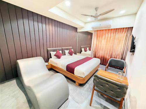 a hotel room with a bed and a chair at Hotel The Avanta - Gandhinagar in Gandhinagar