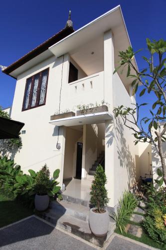 a white house with plants in front of it at Uma Budhas in Ubud