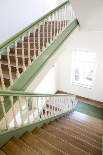 a green staircase in a house with a window at Hotel Müllerbräu in Pfaffenhofen an der Ilm
