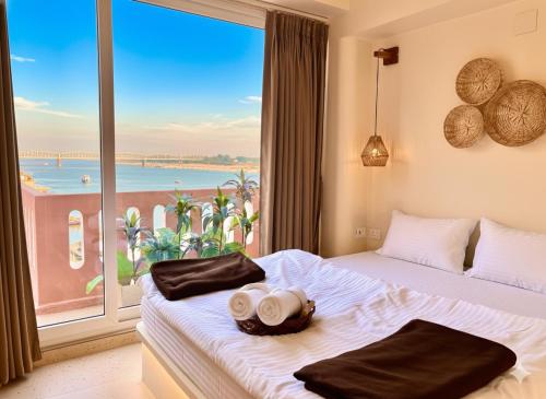 a bedroom with two beds and a large window at Vintage River Homestay in Varanasi