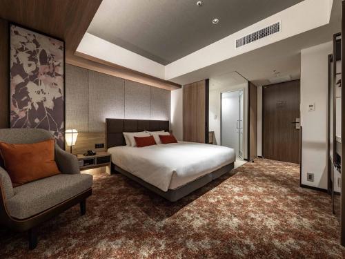 a bedroom with a bed and a chair at Solaria Nishitetsu Hotel Sapporo in Sapporo