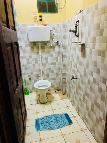 a bathroom with a toilet and a tiled floor at Serenity Suites Studio in Busia