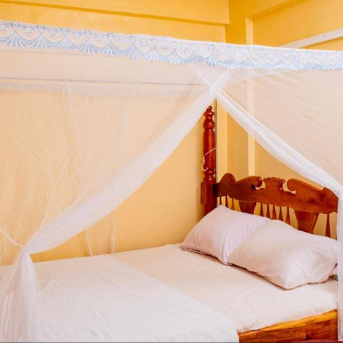 a bedroom with a bed with a canopy at Serenity Suites Studio in Busia