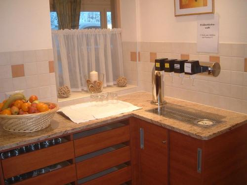 a kitchen counter with a sink and a bowl of fruit at Jugendpension Müllauerhof in Saalbach Hinterglemm
