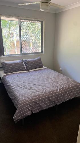 a large bed in a bedroom with a large window at 4 bedrooms with queen sized bed each room in Riverview