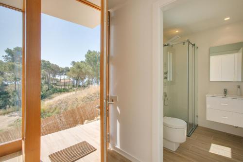 a bathroom with a toilet and a glass door at Villa Rubi in Platja d'Aro