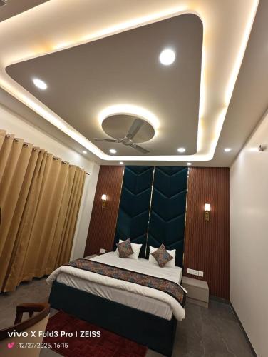 a bedroom with a large bed with a blue headboard at Hotel Akshansh Inn in Agra