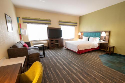 a hotel room with a bed and a tv at Hampton Inn & Suites College Station in College Station