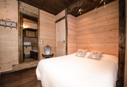 sypialnia z białym łóżkiem w pokoju z drewnianymi ścianami w obiekcie Appartement Jorasses w Chamonix-Mont-Blanc