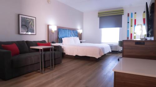 a hotel room with a bed and a couch at Hampton Inn and Suites Houston-Katy in Katy